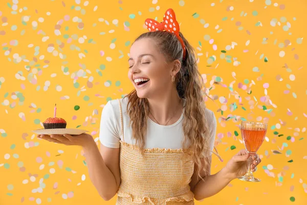 Mujer Joven Feliz Con Muffin Cumpleaños Beber Sobre Fondo Amarillo —  Fotos de Stock