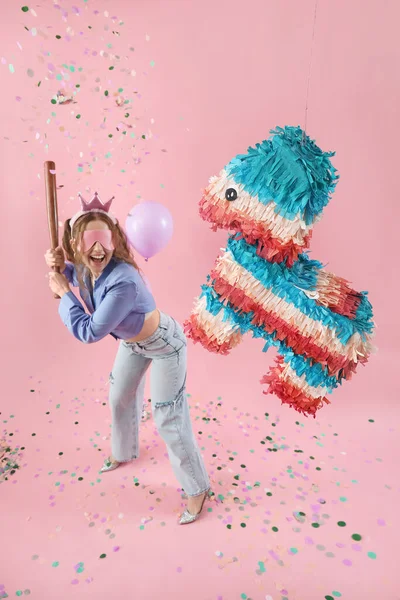 快乐的年轻女子 带着粉红背景的皮纳塔庆祝生日 — 图库照片