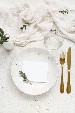 Altın çatal bıçak takımı ve beyaz grunge arka planda boş kart.