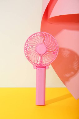Renkli arka planda mini pembe elektrikli fan