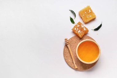 Tatlı ballı kase ve gri arka planda taraklar