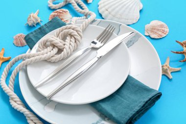 Mavi arka planda deniz dekoruyla servis edilen güzel bir masa.