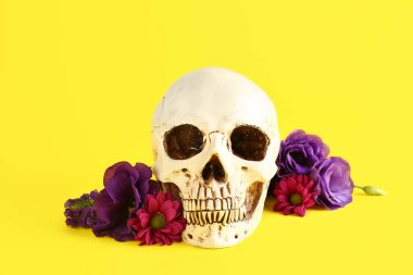 Sarı arka planda güzel çiçekli insan kafatası