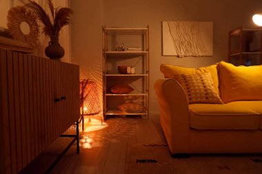 Geceleri kanepede ve parlak lambalarla oturma odasının içinde.