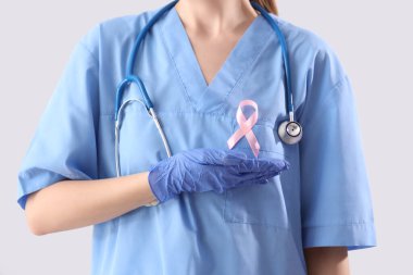 Pembe kurdeleli bayan doktor. Arka planda, yakın plan. Göğüs kanseri farkındalığı konsepti