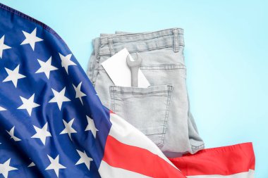 İngiliz anahtarı, tebrik kartı ve mavi arka planda Amerikan bayrağı olan kot pantolonlar. İşçi Bayramı kutlamaları