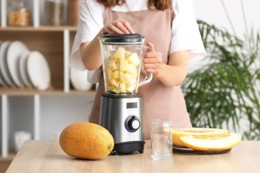 Mutfaktaki masada lezzetli bir kavun püresi hazırlayan kadın.