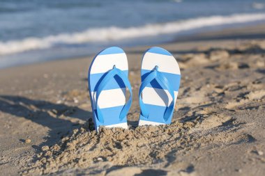 Zarif bayan mavi parmak arası terlikler kumda