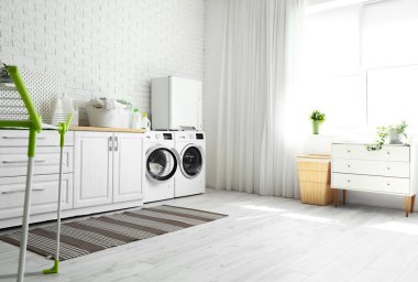 Çamaşır odasının içinde çamaşır makineleri var.