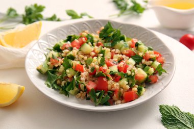 Lezzetli tabakta salata ve arka planda limon, yakın plan.