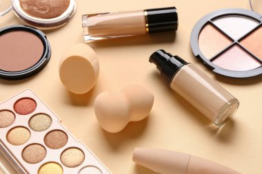 Renkli arka planda makyaj süngerleri ve farklı kozmetikler, yakın plan