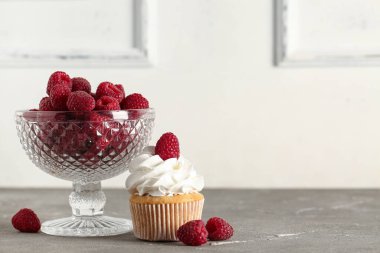 Lezzetli ahududulu kekler ve masada taze böğürtlenli kase.