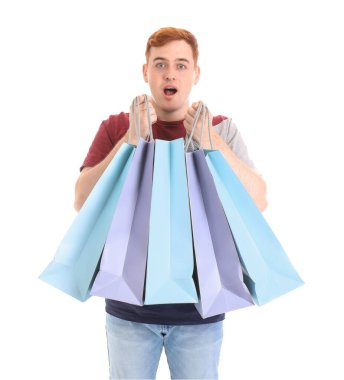 Beyaz arka planda izole edilmiş alışveriş torbalarıyla şok olmuş genç bir kızıl adam. Kara Cuma indirimi