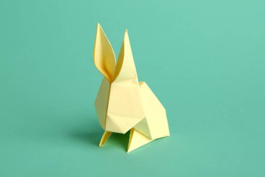 Turkuaz arka planda bej origami tavşanı