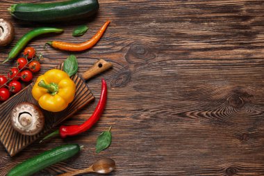 Kahverengi ahşap mutfak masasında taze sebze kesme tahtası.