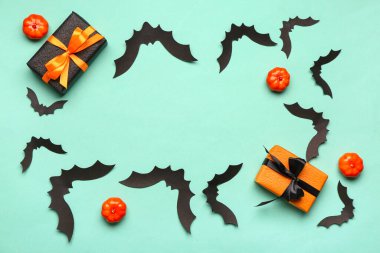 Cadılar Bayramı partisi için balkabaklı kağıt yarasalardan yapılmış çerçeve ve mavi arka planda hediye kutuları