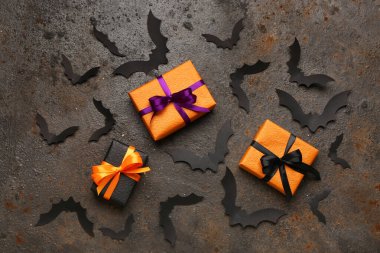 Cadılar Bayramı partisi için kağıt yarasalar ve karanlık arka planda hediye kutuları.