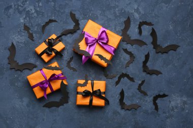 Cadılar Bayramı partisi için kağıt yarasalar ve mavi arka planda hediye kutuları.