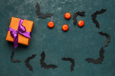 Cadılar Bayramı partisi için balkabaklı kağıt yarasalardan yapılmış çerçeve ve yeşil arka planda hediye kutusu