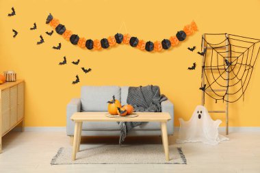 Oturma odasının içi Cadılar Bayramı için kanepe ve masa ile dekore edilmiş.