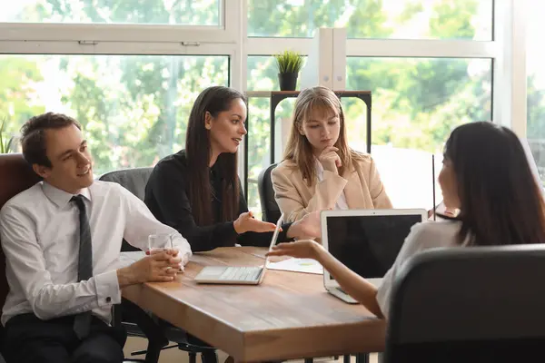 Group of business consultants working at table in office