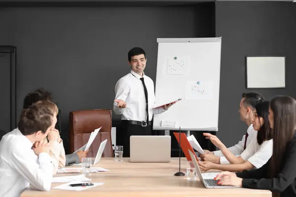 Male business consultant giving presentation to his colleagues in office