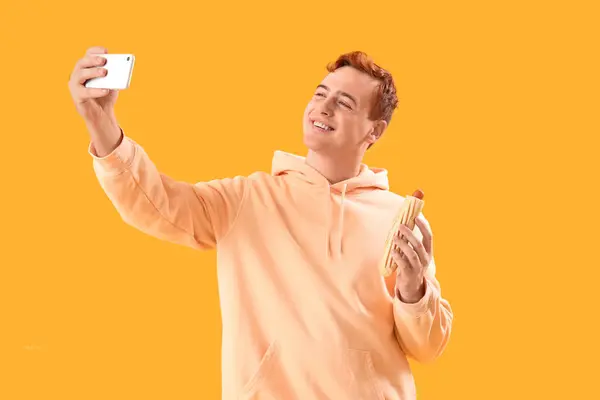 Jongeman Met Lekkere Hotdog Selfie Gele Achtergrond — Stockfoto