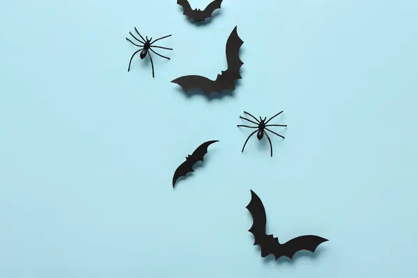 蓝色背景的万圣节派对纸制蝙蝠和蜘蛛 — 图库照片