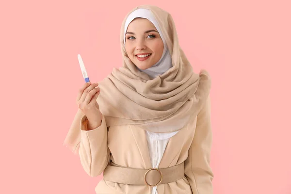ピンクの背景に妊娠テストをした幸せなムスリムの若い女性の肖像画 — ストック写真