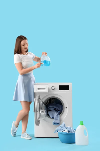 Jovem Com Detergente Para Roupa Máquina Lavar Roupa Fundo Azul — Fotografia de Stock