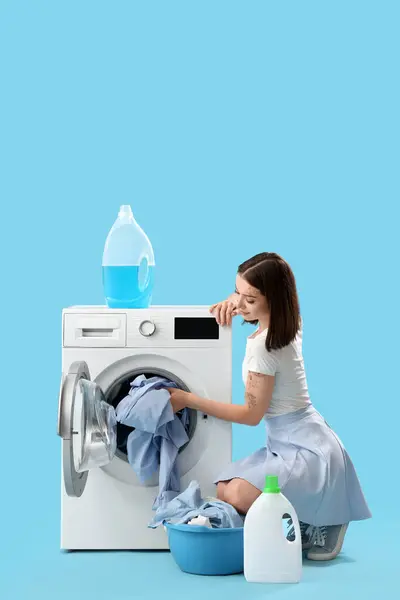 Νεαρή Γυναίκα Πλυντήριο Ρούχων Κάνει Πλυντήριο Μπλε Φόντο — Φωτογραφία Αρχείου