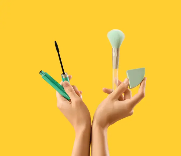 stock image Woman with makeup products on yellow background