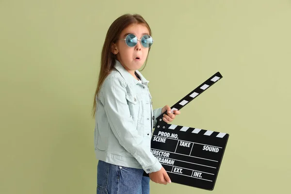 Zszokowana Dziewczynka Okularach Przeciwsłonecznych Klaskaczem Filmowym Zielonym Tle — Zdjęcie stockowe