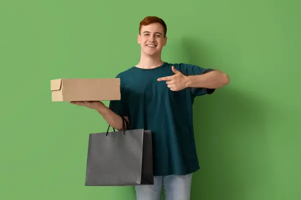 Glücklicher Junger Rothaariger Mann Mit Einkaufstasche Der Auf Einen Karton — Stockfoto