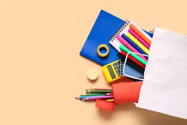 stock image Shopping bag with different school stationery on beige background