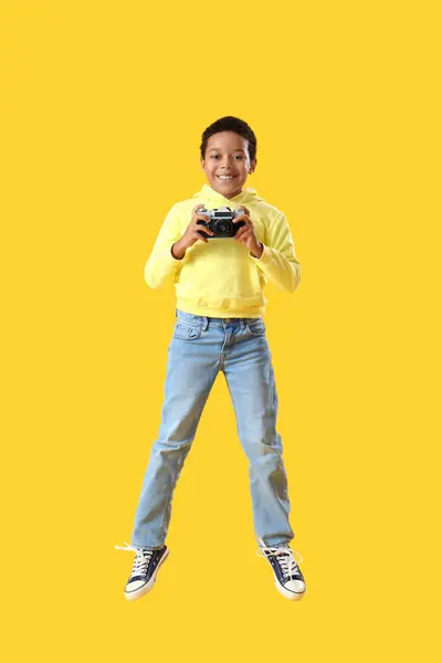 Niño Afroamericano Con Cámara Fotos Saltando Sobre Fondo Amarillo — Foto de Stock