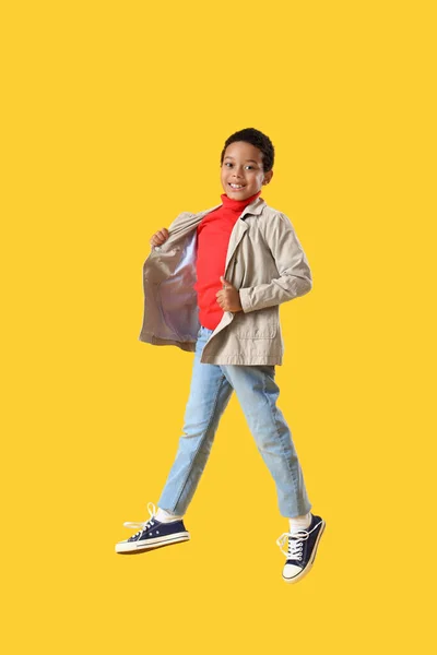 アフリカ系アメリカ人の少年が黄色い背景に飛び跳ねる — ストック写真