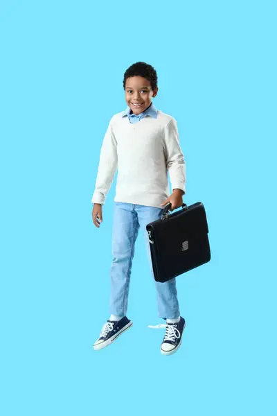 Niño Afroamericano Con Maletín Saltando Sobre Fondo Azul — Foto de Stock