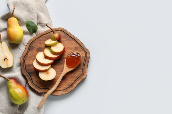 Wooden board with spoon of tasty pear jam on white background