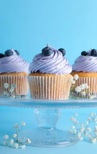 Stand Sabrosos Cupcakes Con Arándanos Sobre Fondo Azul —  Fotos de Stock