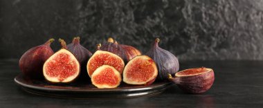 Siyah arka planda taze taze incir tabağı