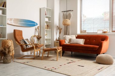 Sörf tahtası, kahverengi kanepesi ve koltuğu olan bir oturma odası.