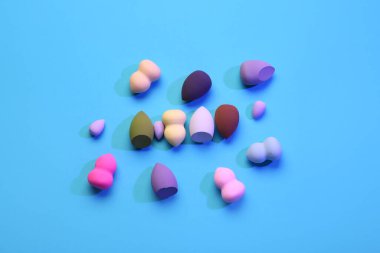 Mavi arkaplanda farklı makyaj süngerleri