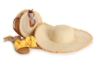 Havalı plaj şapkası, çanta, güneş gözlüğü ve beyaz arka planda parmak arası terlikler.