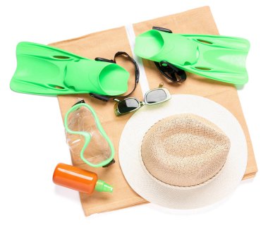 Havalı plaj şapkası, yüzme maskesi, palet, güneş gözlüğü ve beyaz arka planda bir şişe güneş kremi.