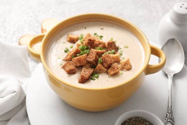 Gri arka planda kızarmış ekmekli lezzetli krema çorbası.