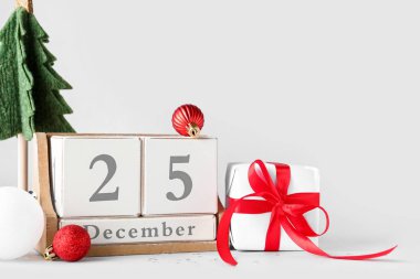 Hediye kutusu, dekorasyon ve takvim. Beyaz arka planda Noel tarihi.