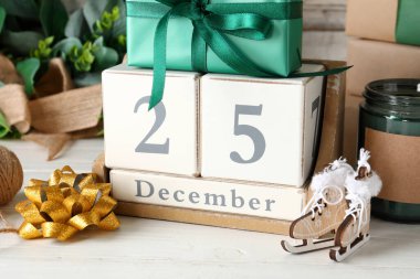 Dekorasyonlar, hediye kutuları, mum ve takvimde Noel tarihi tahtadan arka planda.