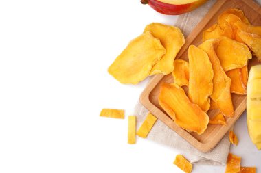 Beyaz arka planda kurutulmuş mango dilimleri olan ahşap tahta.
