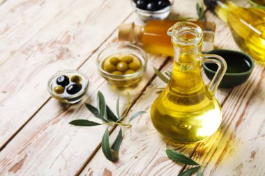 Beyaz ahşap arka planda taze zeytinyağlı sürahi.